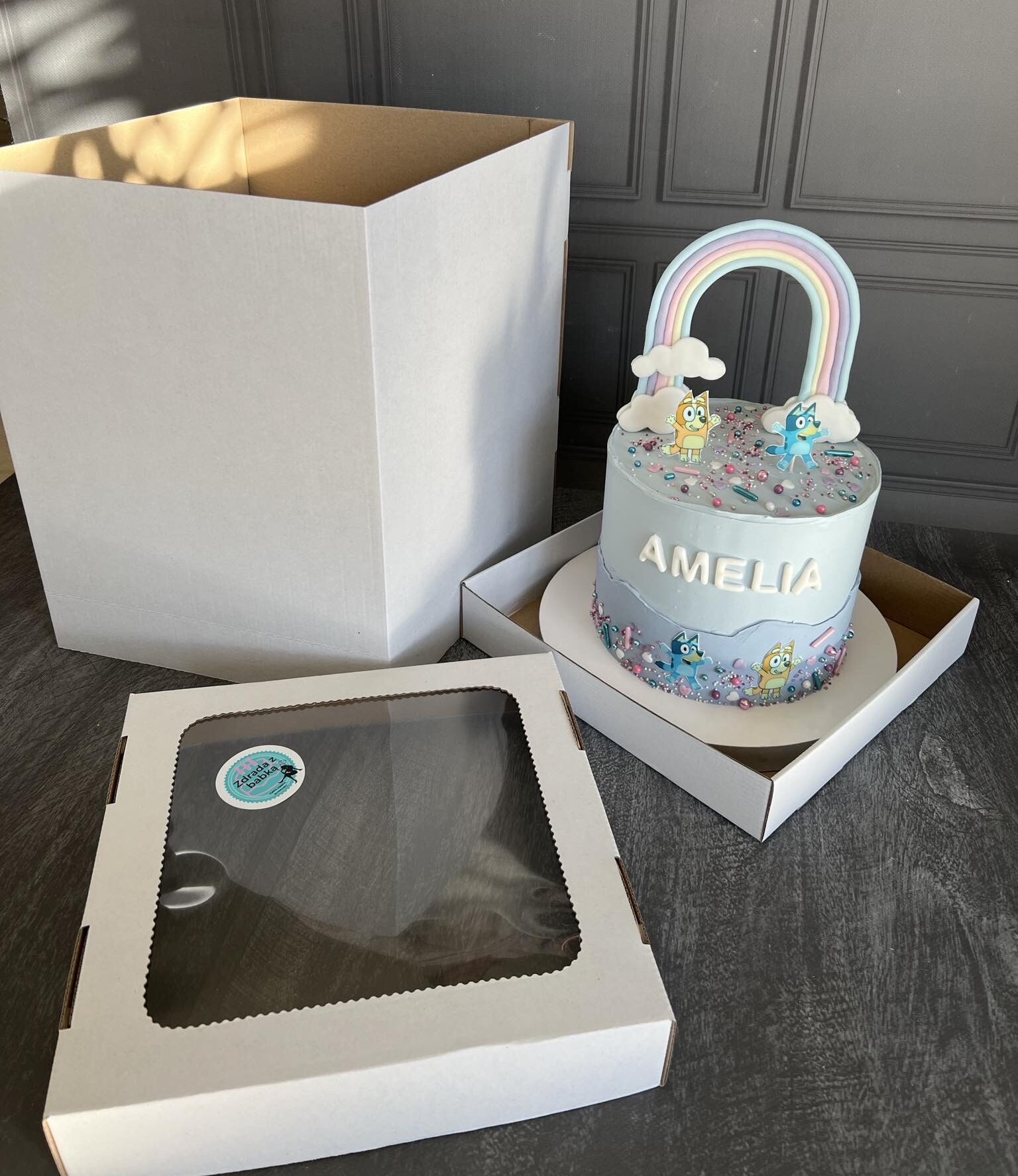 niebieski tort stoi obok pudełka tekturowego na tort