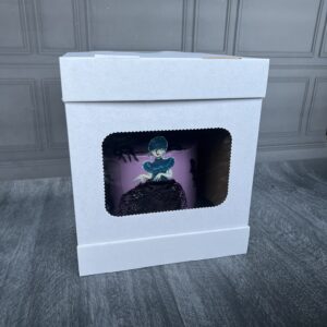 Obraz przedstawia pudełko na tort z okienkiem z tortem w środku